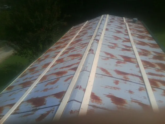 Rusted metal roof panels with new wood purlins before replacement — Storm Damage Roof Repair in Pinckney by Roofing Brothers