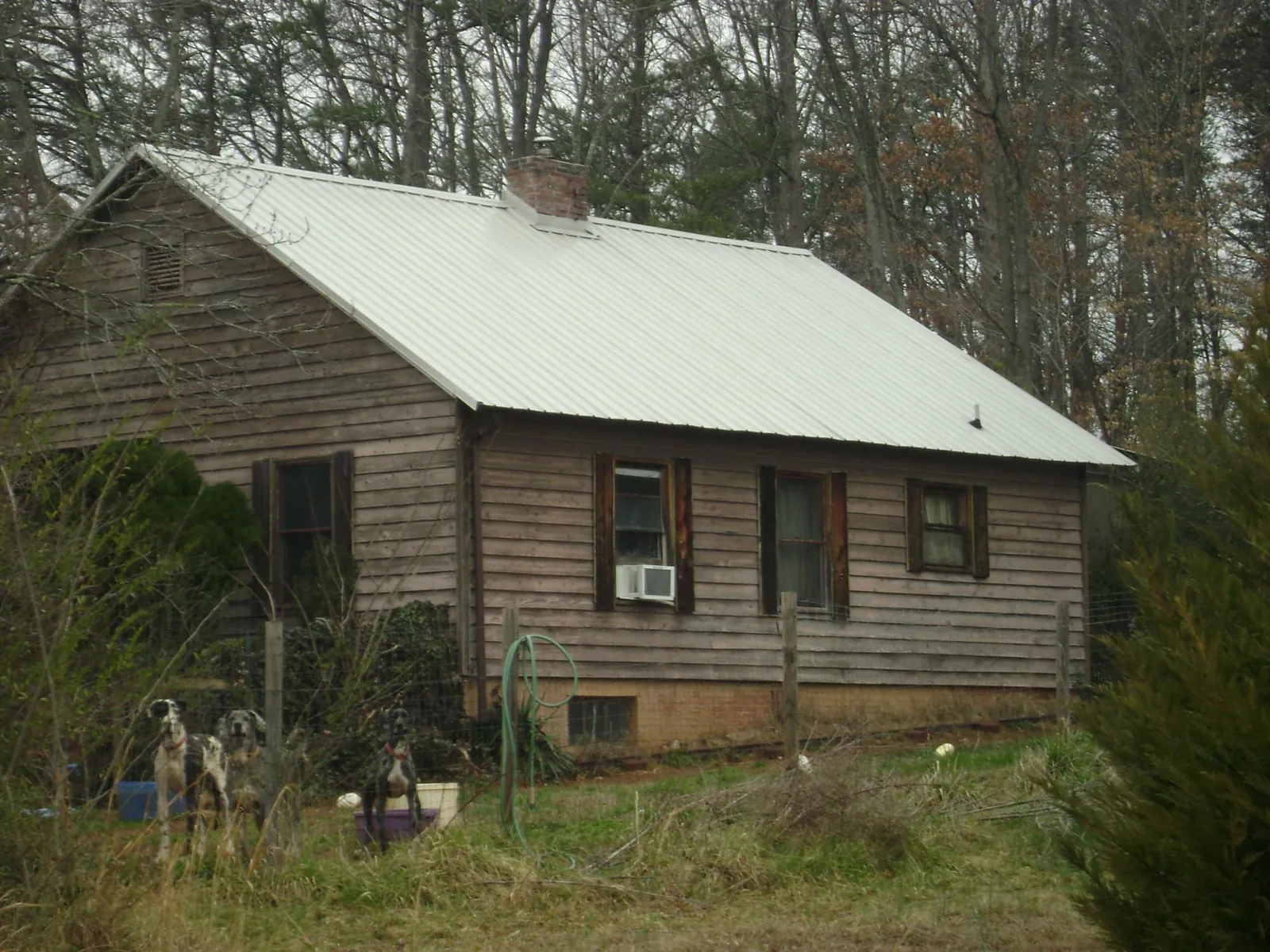 White metal roof on an old wood sided farmhouse, from a Metal Roof Installation job in Pinckney